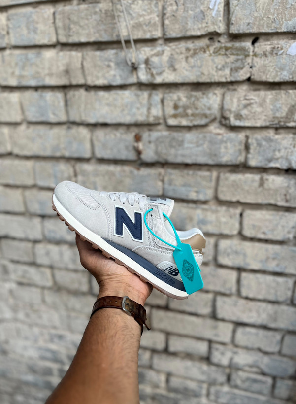 کفش نیوبالانس 574 اصل خاکستری، طراحی اسپرت با لوگو سرمهای و جزئیات طلایی – مناسب استایل روزمره و کتانی اسپرت شیک